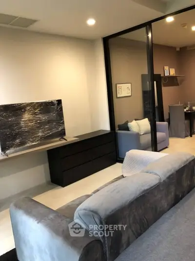 Modern living room with sleek furniture and large TV, perfect for relaxation and entertainment.