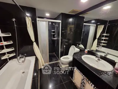 Luxurious black-tiled bathroom with bathtub and modern fixtures