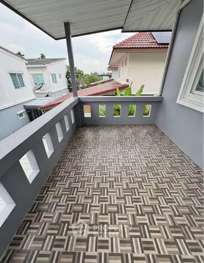 Spacious balcony with patterned tile flooring and scenic neighborhood view.