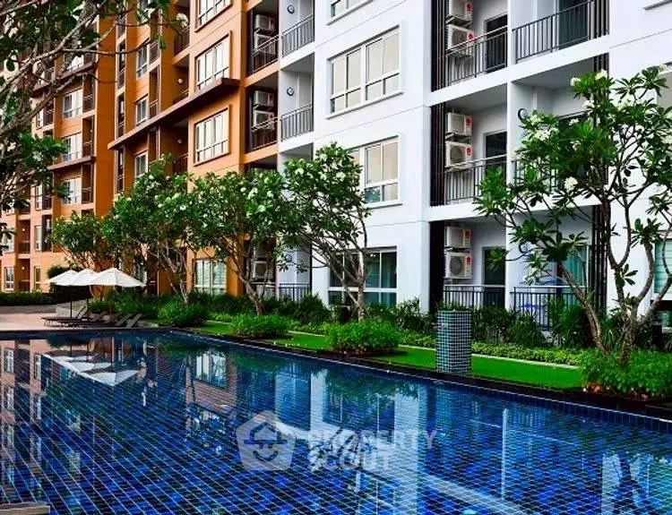 Modern apartment complex with pool and lush greenery