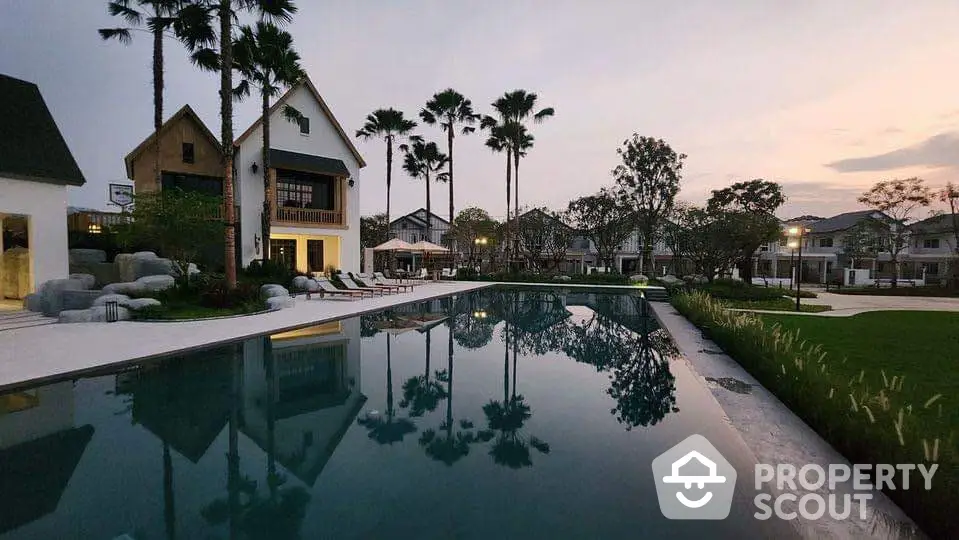 Luxurious residential pool area with elegant landscaping and modern architecture at sunset.