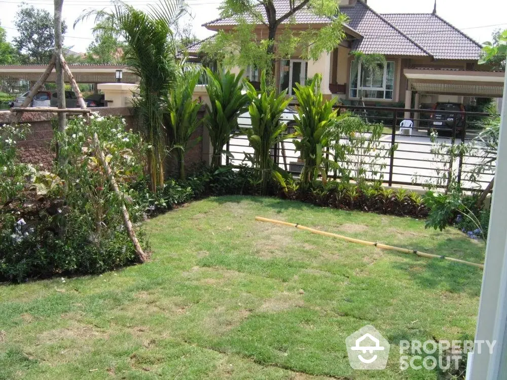 Lush green garden space with tropical plants, perfect for outdoor relaxation and family gatherings, enhancing the serene suburban home appeal.