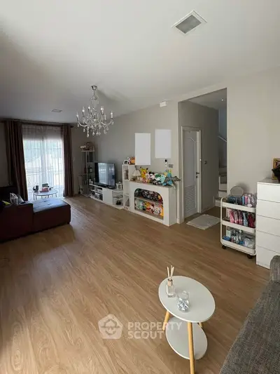 Spacious living room with elegant chandelier and modern decor