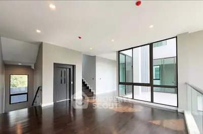 Spacious modern living room with large windows and sleek wooden flooring