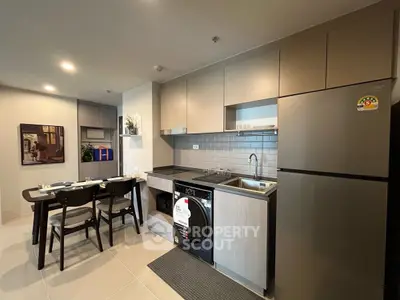Modern kitchen with dining area, featuring sleek appliances and stylish cabinetry.
