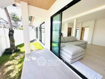 Modern living room with large sliding glass doors opening to a lush garden patio.