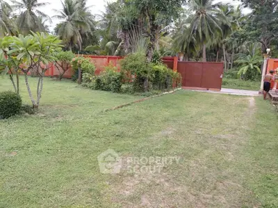 Spacious tropical garden with lush greenery and palm trees, perfect for outdoor relaxation and entertainment.