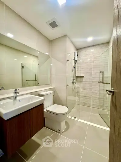 Modern bathroom with sleek design, glass shower, and elegant fixtures.