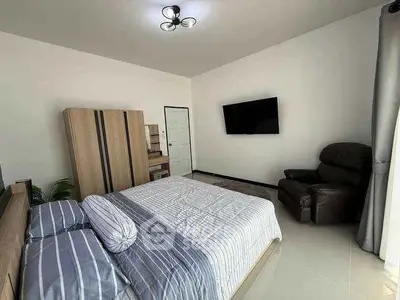 Spacious modern bedroom with stylish furniture and wall-mounted TV