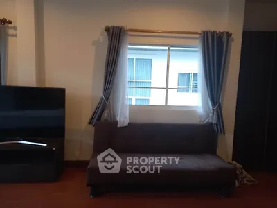 Cozy living room with modern sofa and large window view.