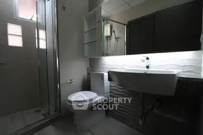 Modern bathroom with sleek fixtures and glass shower enclosure