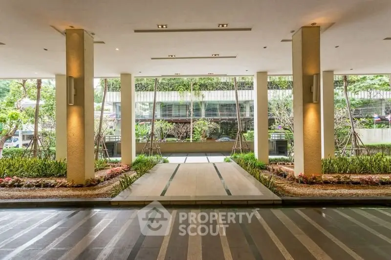 Elegant building entrance with landscaped garden and modern design