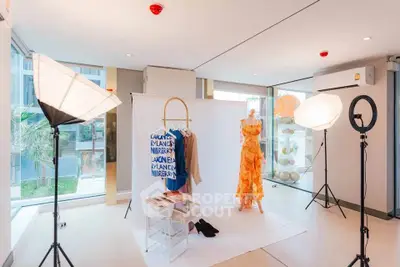 Modern interior space with fashion photo shoot setup and large windows.