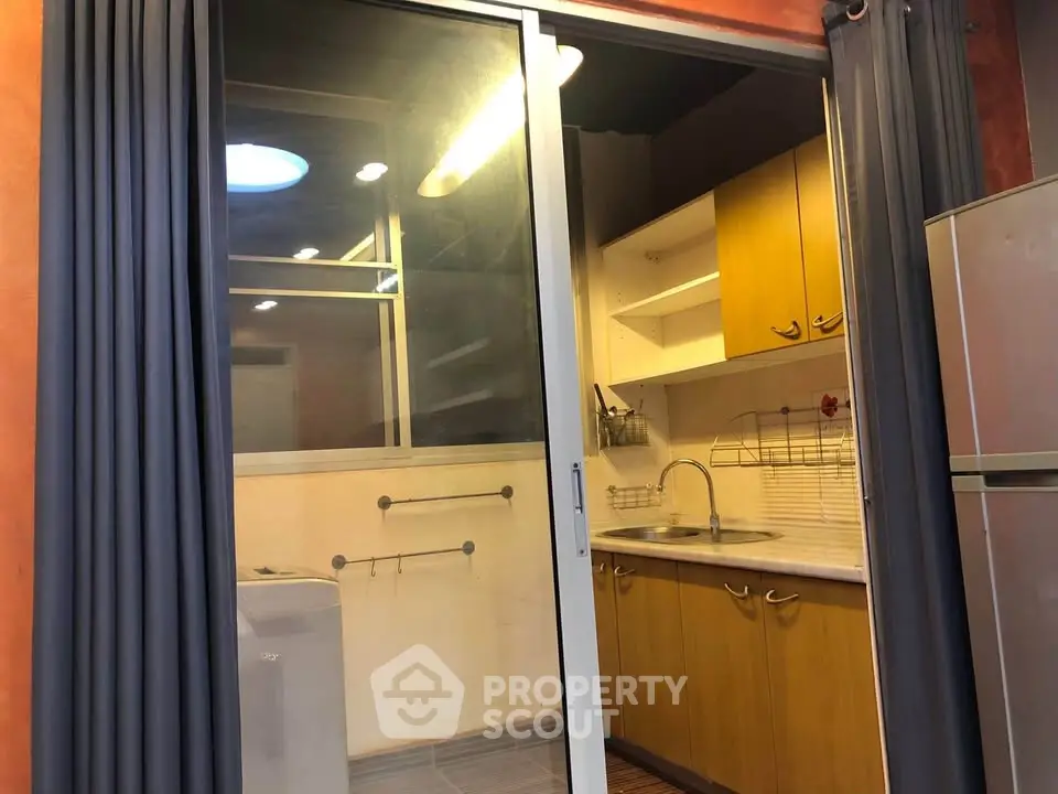Cozy kitchen with sliding glass door and modern appliances in a stylish apartment.