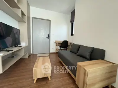 Modern living room with sleek furniture and wooden flooring in a cozy apartment.
