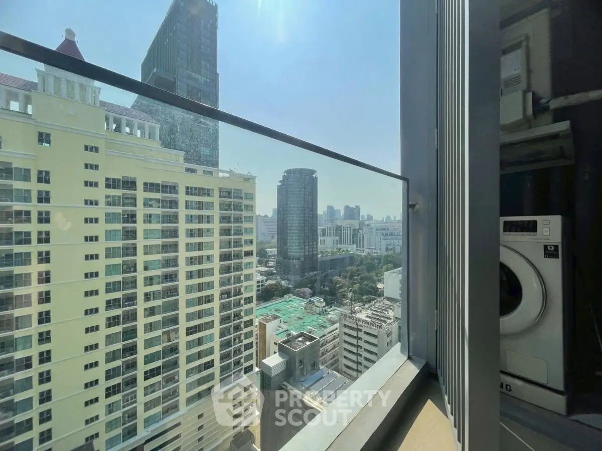 Stunning city view from high-rise apartment balcony with modern washing machine.