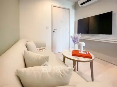 Modern living room with sleek TV setup and cozy beige sofa