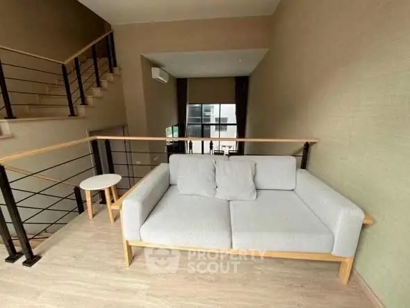 Modern loft with stylish sofa and elegant staircase in open living area.