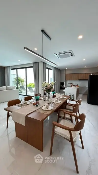 Luxurious open-plan kitchen and dining area with modern decor and natural light.