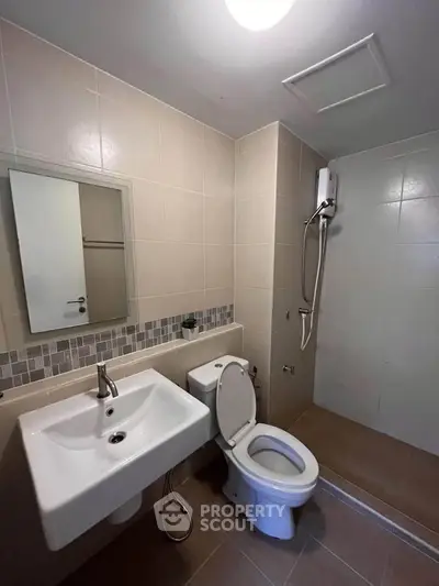 Modern bathroom with sleek fixtures and walk-in shower in a contemporary apartment.