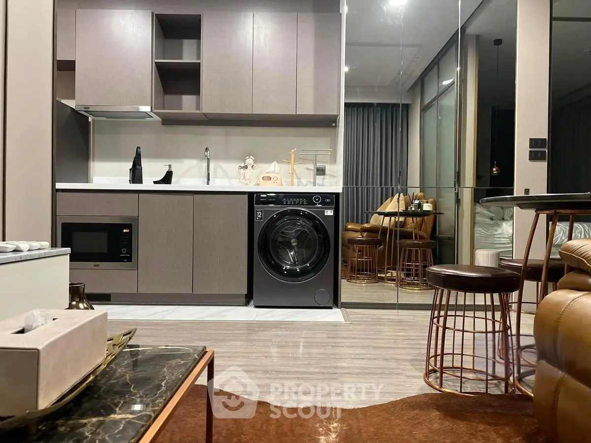 Modern kitchen with integrated appliances and stylish decor in a contemporary apartment.
