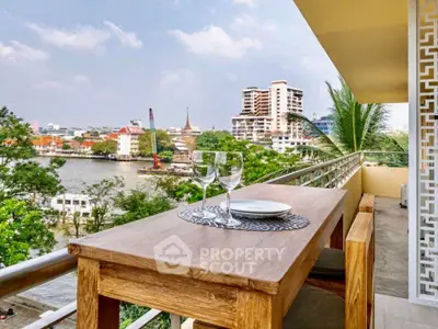 Stunning balcony view with river and cityscape, perfect for relaxation and dining.