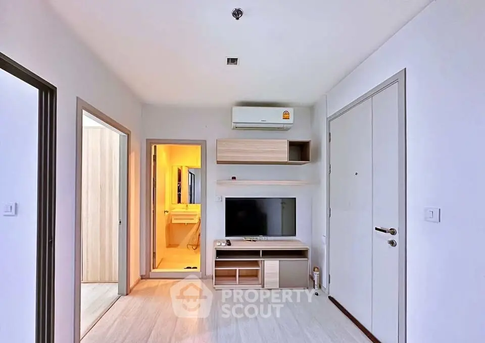 Modern living room with sleek TV setup and air conditioning in a cozy apartment.