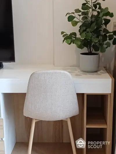 Modern study area with sleek desk, stylish chair, and decorative plant enhancing the workspace ambiance.