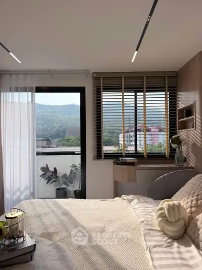 Cozy bedroom with mountain view and stylish decor, featuring large windows and natural light.