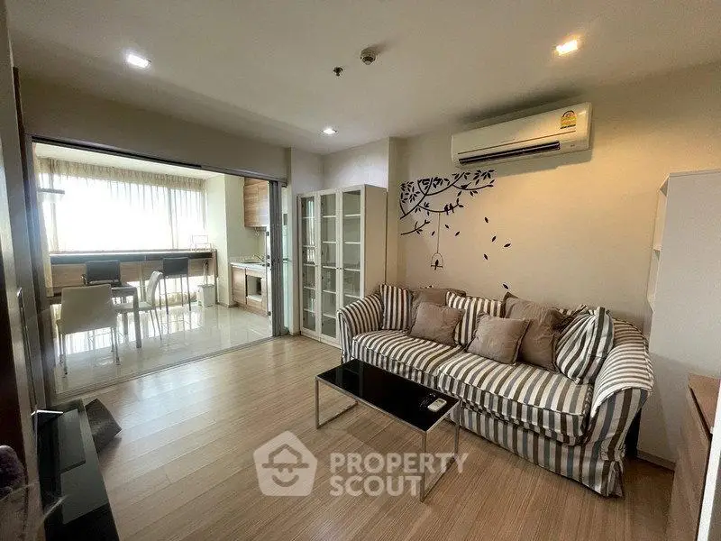 Modern living room with striped sofa and open kitchen layout