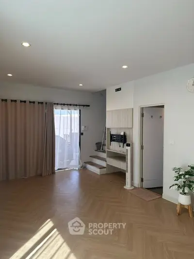 Spacious modern living room with natural light and elegant wooden flooring