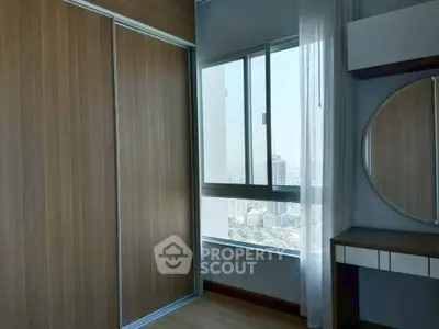 Modern bedroom with city view, built-in wardrobe, and stylish vanity mirror.