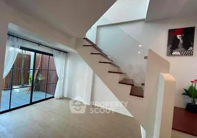 Modern interior with stylish staircase and glass doors leading to patio