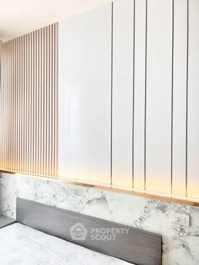 Modern bedroom with stylish wall paneling and ambient lighting