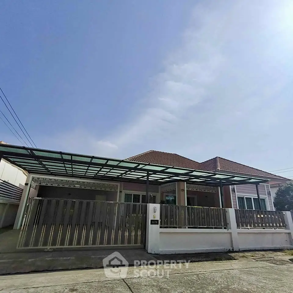 Charming single-story home with spacious driveway and modern fence in a serene neighborhood.