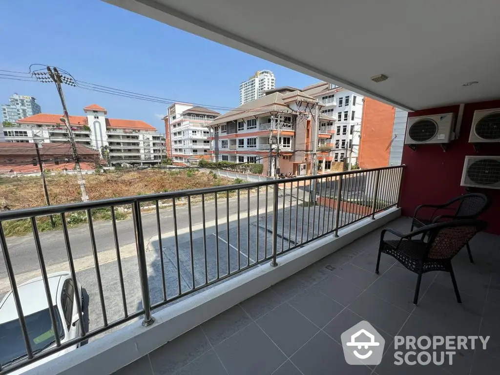 Spacious balcony with urban views, featuring a relaxing seating area and overlooking a bustling cityscape, perfect for outdoor entertainment or a serene retreat.