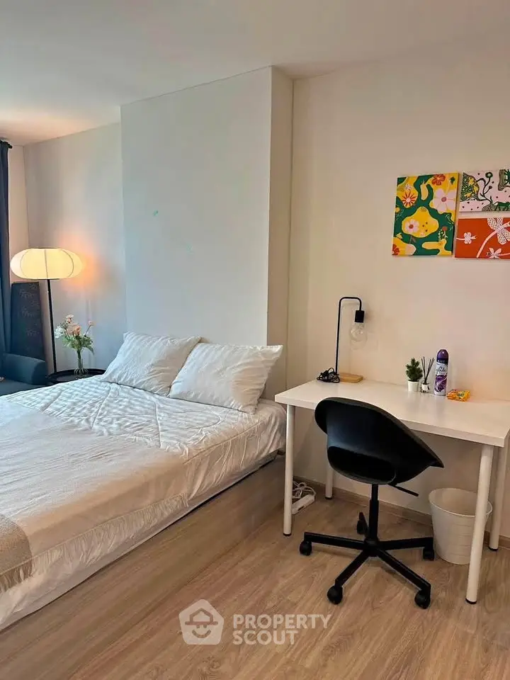 Modern bedroom with cozy bed, stylish desk, and elegant decor in a bright apartment.
