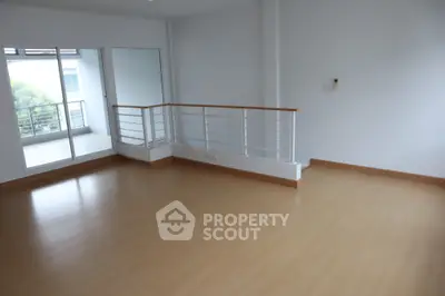Spacious empty room with wooden flooring and balcony access, ideal for customization and personal touch.