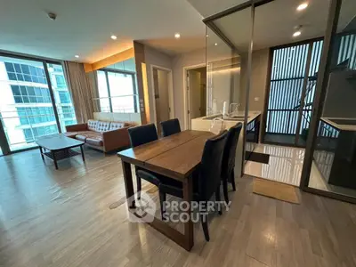 Spacious modern living room with dining area and large windows in luxury apartment.