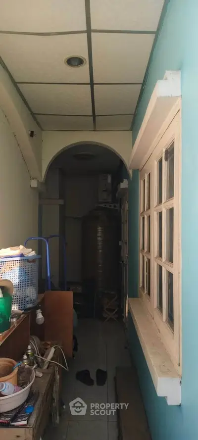 Narrow corridor with storage items and window, potential for creative use in home design.