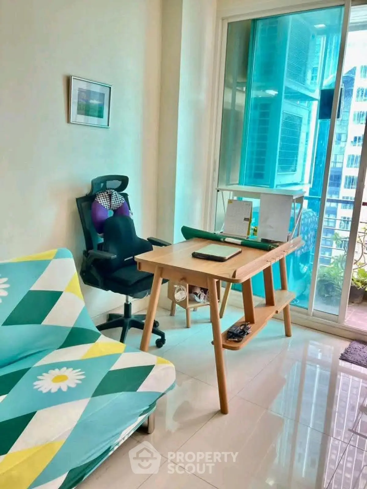 Bright study room with modern desk and ergonomic chair, overlooking a city view balcony.