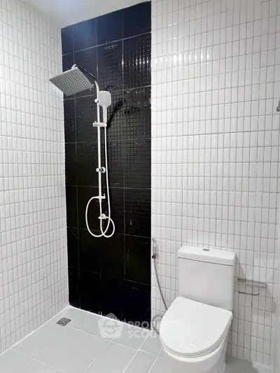 Modern bathroom with sleek black and white tile design and contemporary shower.