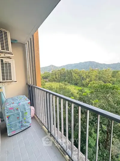 Scenic balcony view with lush greenery and mountains, perfect for relaxation.
