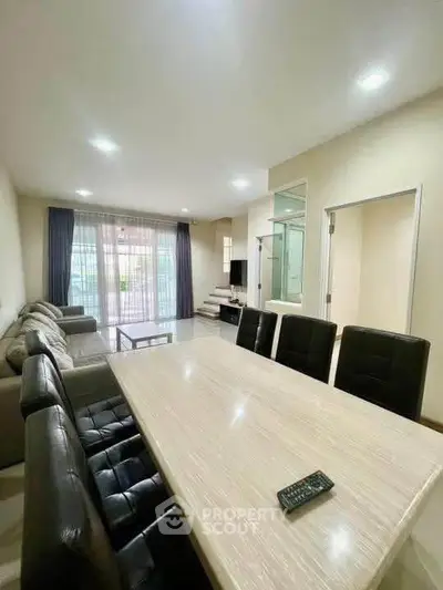 Spacious modern living room with dining area and large windows for natural light.