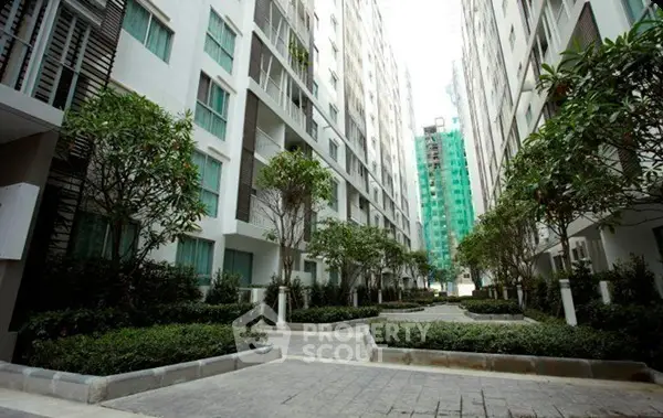 Modern apartment complex exterior with lush landscaping and tall buildings.