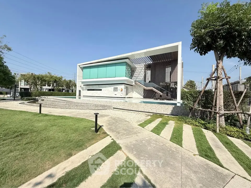Modern architectural building with sleek design and lush green surroundings.