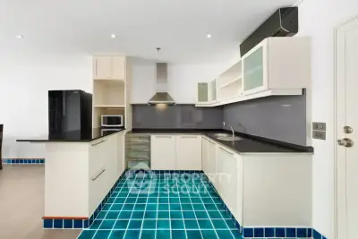 Modern kitchen with sleek cabinetry and vibrant blue tile flooring