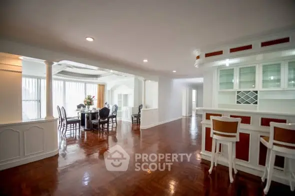 Spacious open-plan living and dining area with elegant hardwood floors and natural light.
