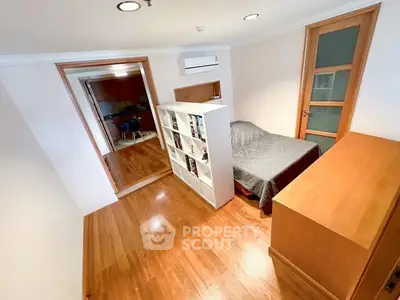 Cozy bedroom with wooden flooring and modern furniture