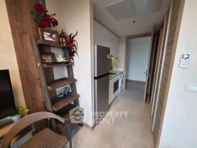 Modern kitchen with sleek appliances and stylish shelving in a cozy apartment setting.